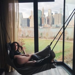 Mistress Blunt lounging in a hammock, overlooking NYC.