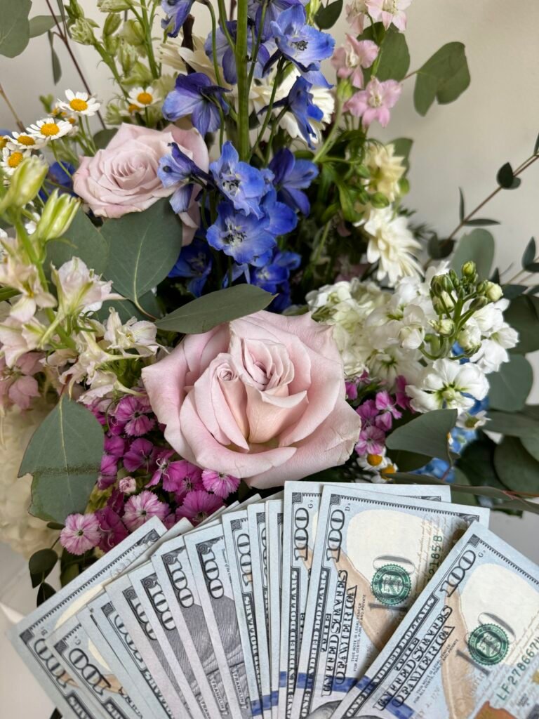 Mistress Blunt holds up findom cash drop in front of flowers